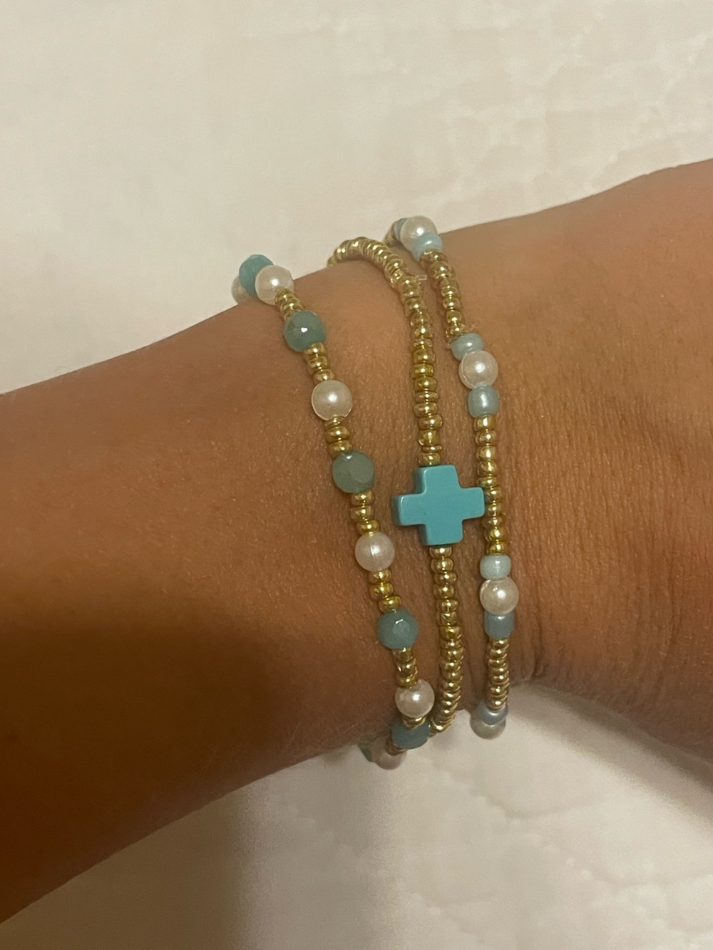 SET OF 3 gold, pearl, blue bracelets with a enewton cross.